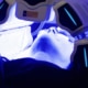 Patient undergoing pre-surgical blue light therapy before facelift surgery to cleanse the skin and reduce bacteria for optimal recovery