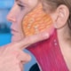 Dr. Richard Balikian demonstrating facelift anatomy with face painting showing SMAS and platysma muscle layers of the cheek and neck