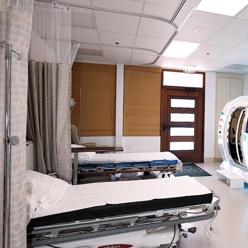 Postoperative recovery room with patient recovery beds, privacy curtains, and supportive healing equipment used during facial surgery recovery and postoperative monitoring.